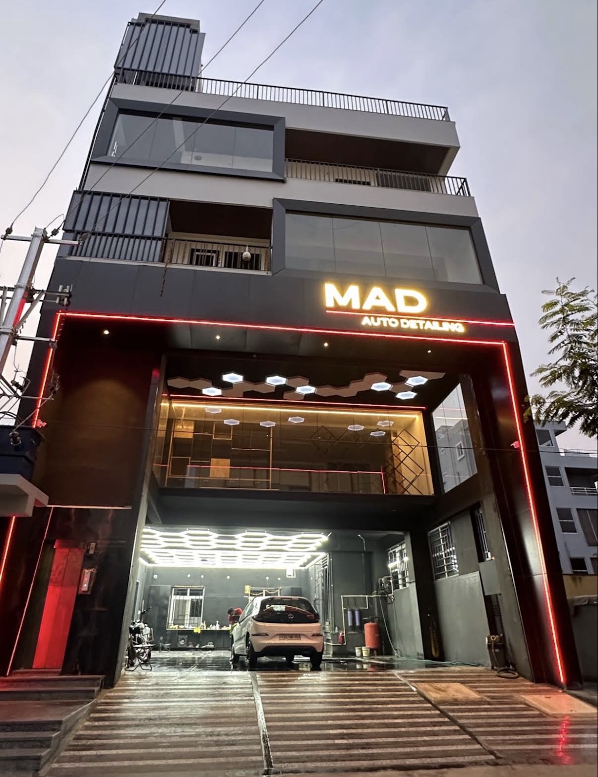 MAD Auto Detailing Studio — car being washed under hexagon lights